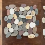 Three pebble mosaic sheets side by side: black sliced pebble, mixed-colour river pebble and tan and white river pebble